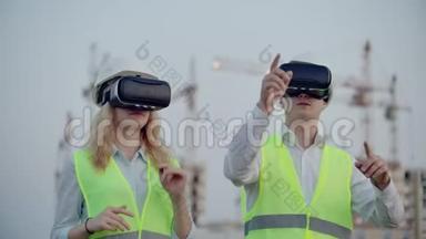 建筑工地的两名未来检查员在建筑物和建筑物的背景上使用虚拟现实眼镜。
